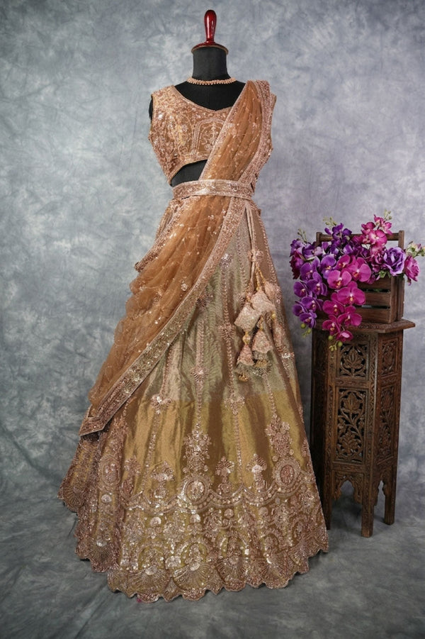 Antique Gold Lehenga Choli - with rich zari & sequin embroidery, floral medallion motifs, scalloped border, rose-gold threadwork, gracefully draped dupatta & ornate tassel detailing. Ideal for bridal & festive celebrations.