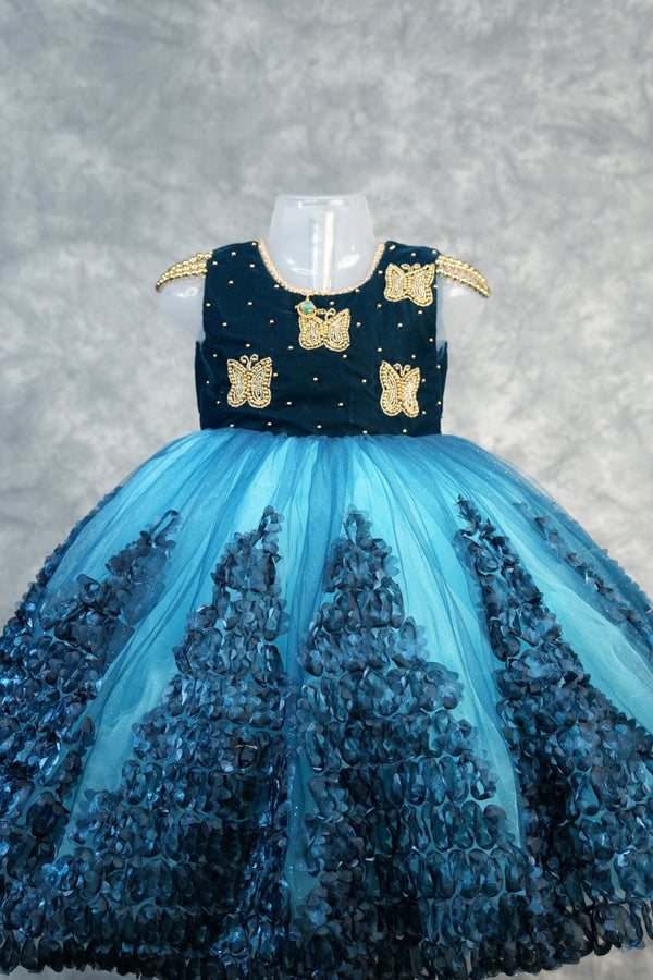 Deep Teal with Peacock Blue Baby Girls Frock Rich teal velvet bodice with gold butterfly appliqués & pearl dots, flowy peacock blue tulle skirt with 3D petal clusters.Birthday party wear!