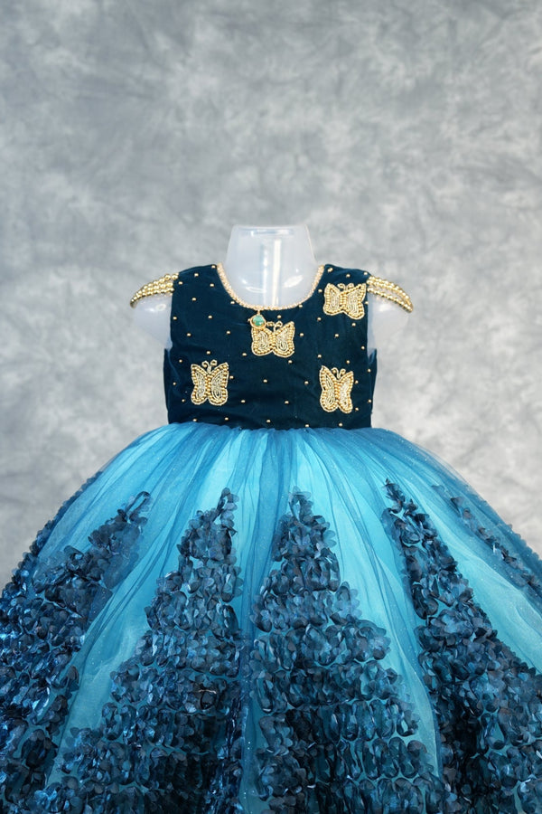 Deep Teal with Peacock Blue Baby Girls Frock Rich teal velvet bodice with gold butterfly appliqués & pearl dots, flowy peacock blue tulle skirt with 3D petal clusters.Birthday party wear!