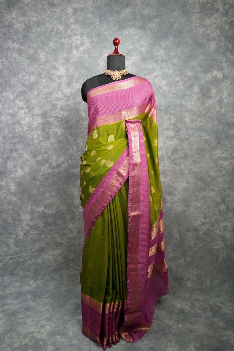 Green and pink saree on a mannequin against a gray background