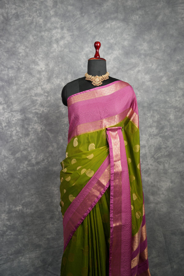 Green and pink saree on a mannequin with a gray background