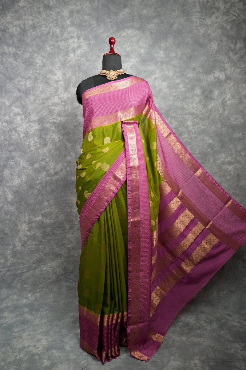 Green and pink saree on a mannequin against a gray background