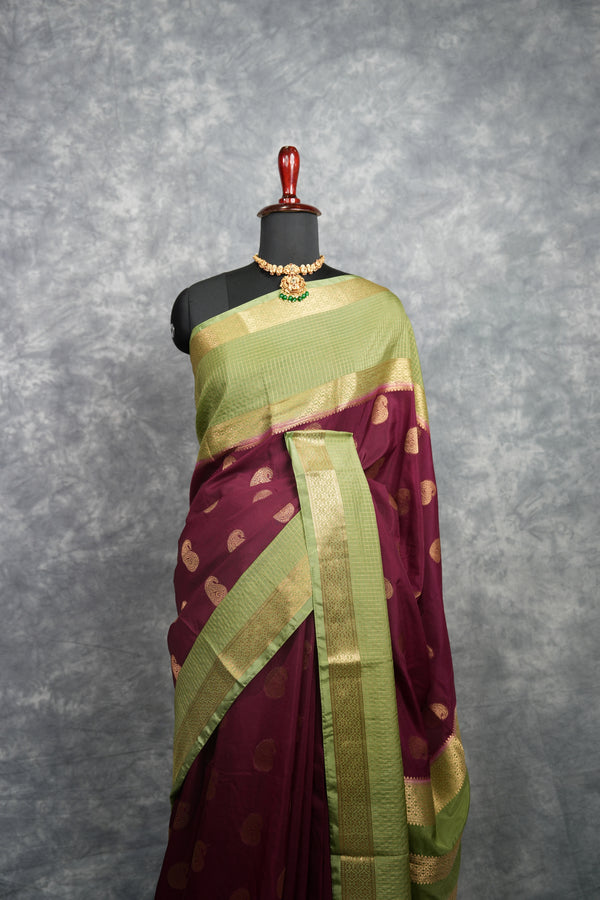 Saree with a green and maroon pattern on a mannequin against a gray background