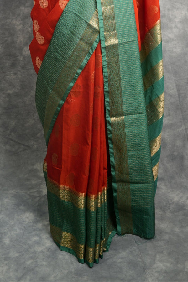 Red and green saree with gold border on a mannequin against a gray background