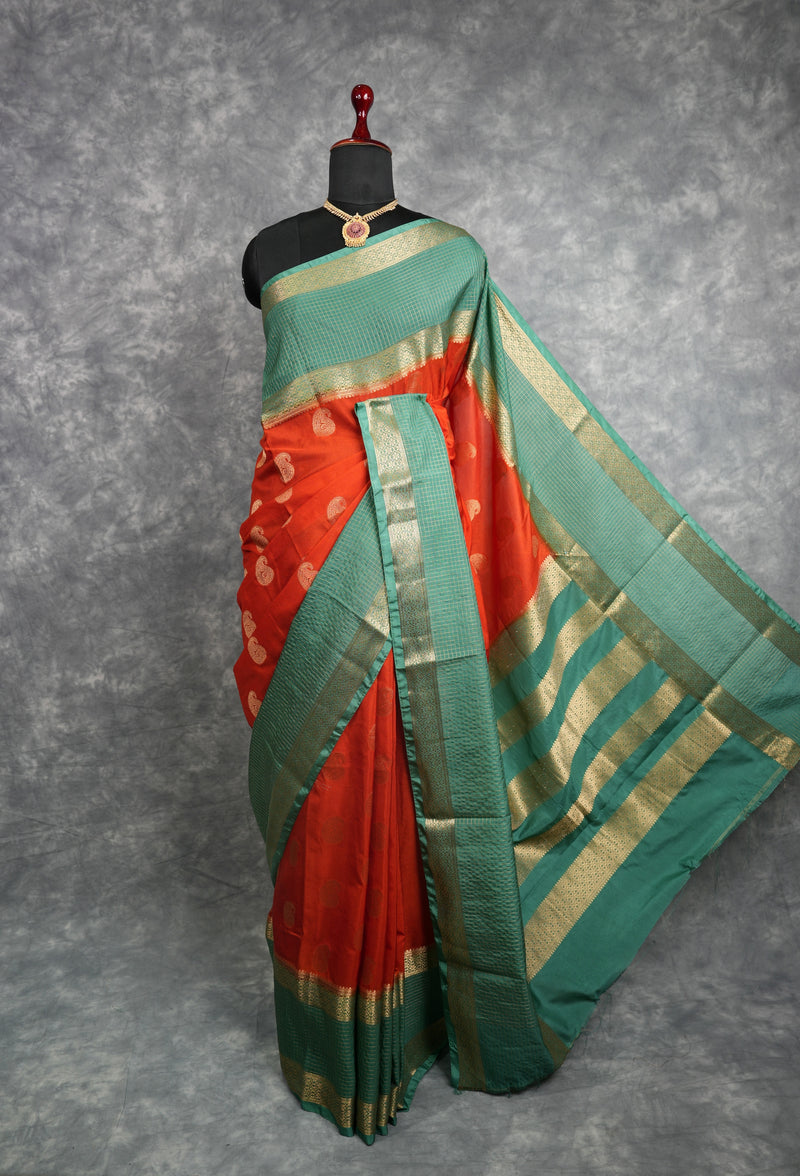 Green and red saree with gold border on a mannequin against a gray background