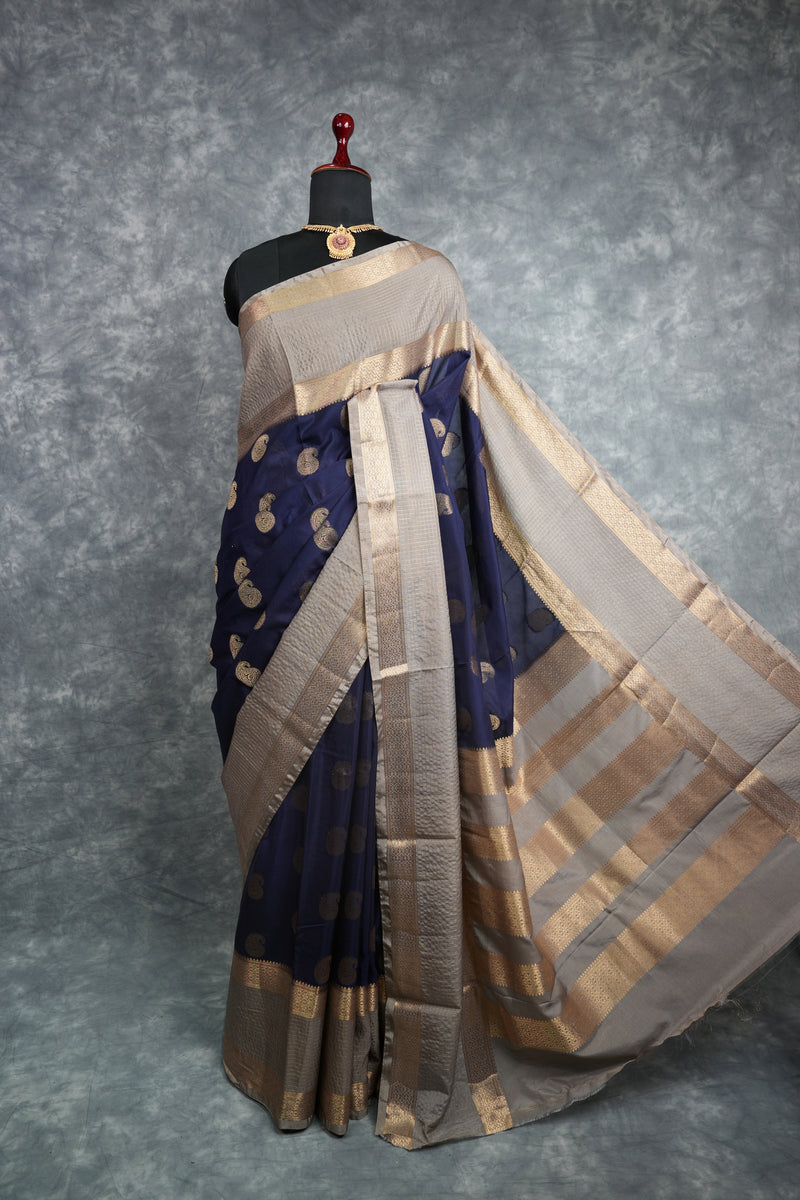 Saree with blue and beige patterns on a mannequin against a gray background