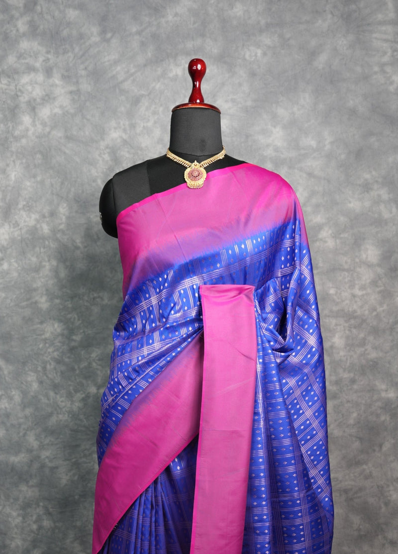 Blue and pink saree on a mannequin against a gray background