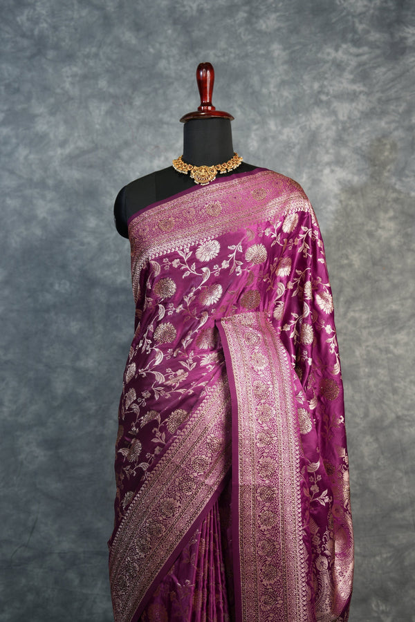 Purple saree with gold patterns on a mannequin against a gray background