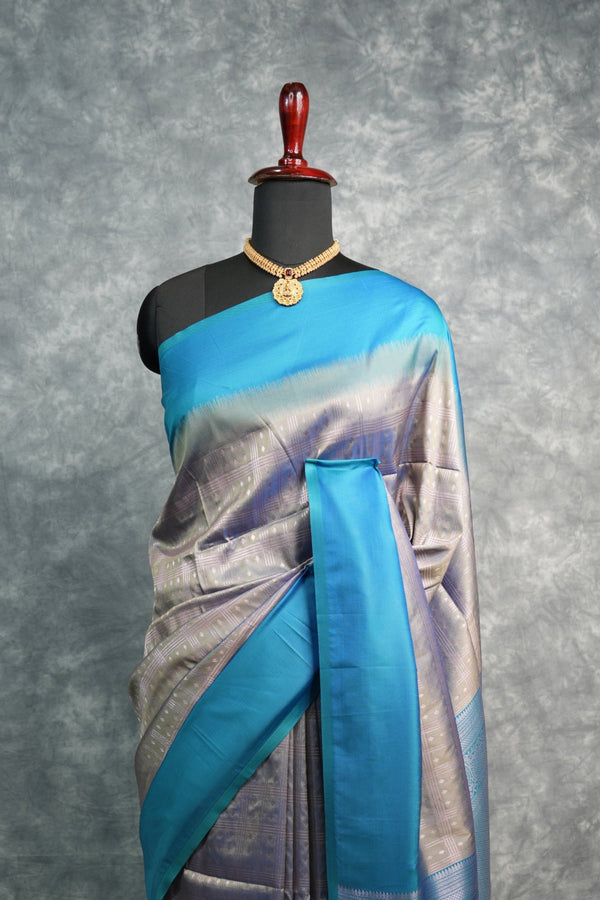 Saree with blue and silver design on a mannequin against a gray background