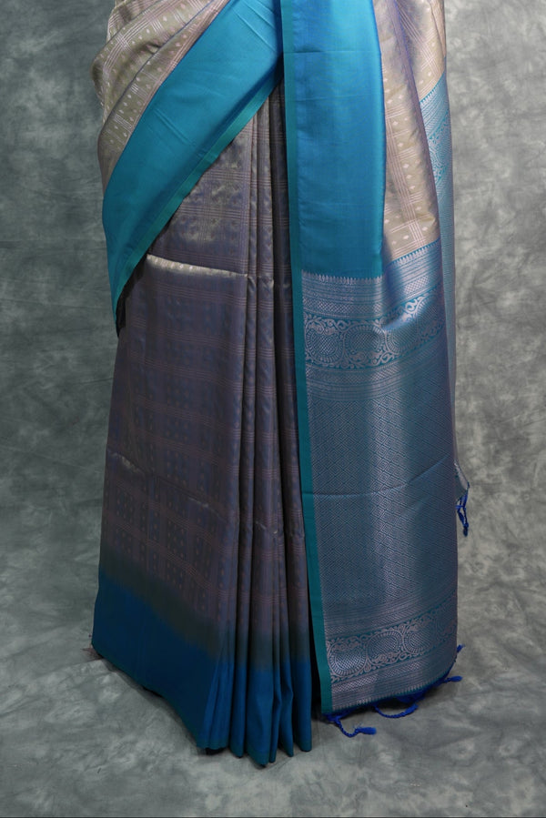 Saree with blue and silver design on a mannequin against a gray background