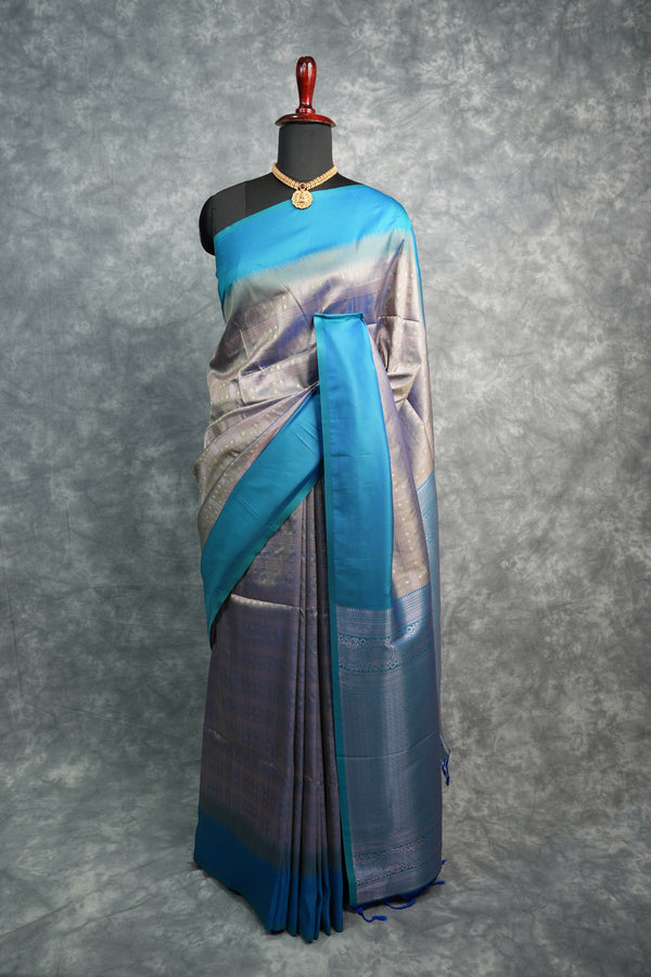 Saree with blue and silver design on a mannequin against a gray background