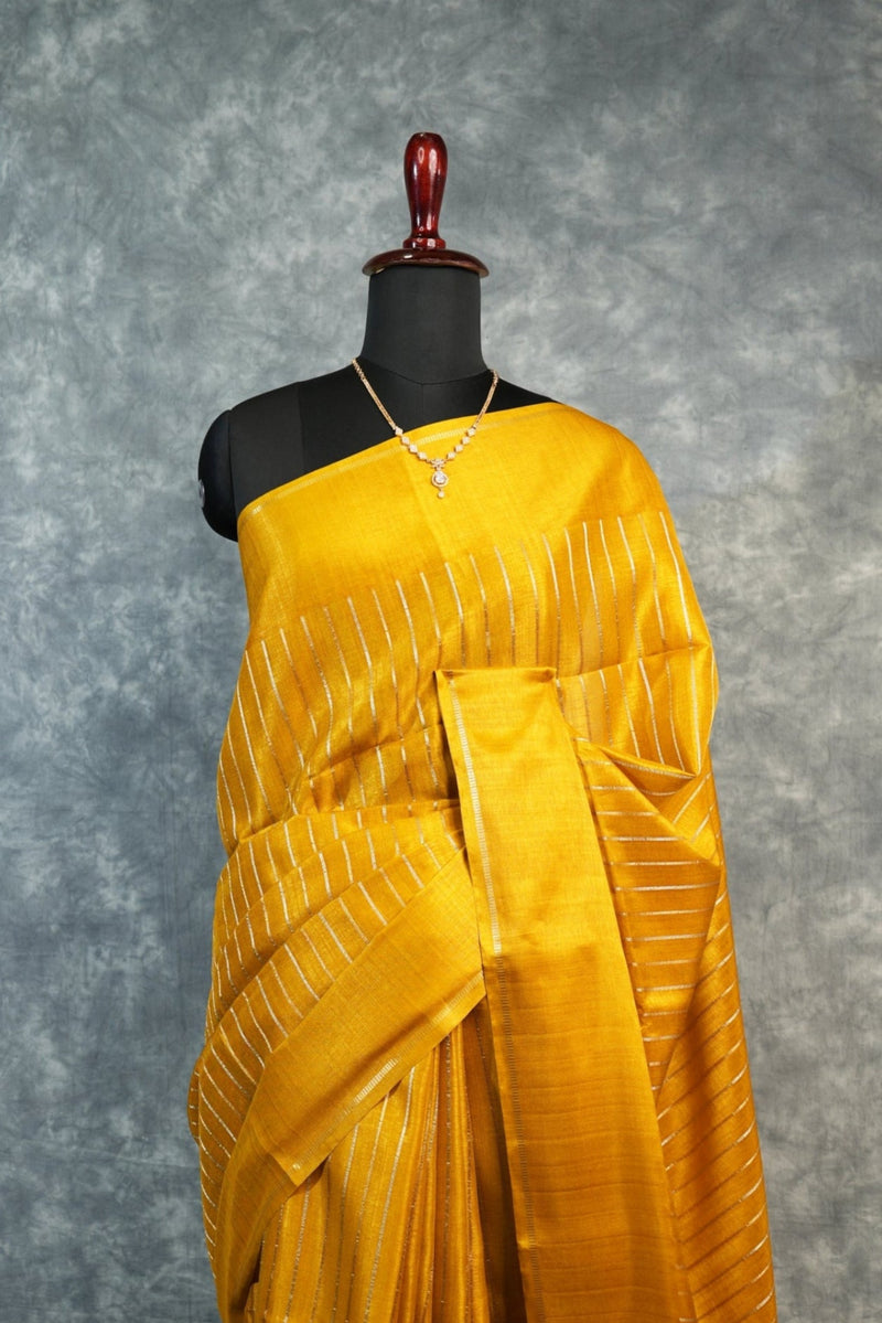 Yellow saree on a mannequin against a gray background