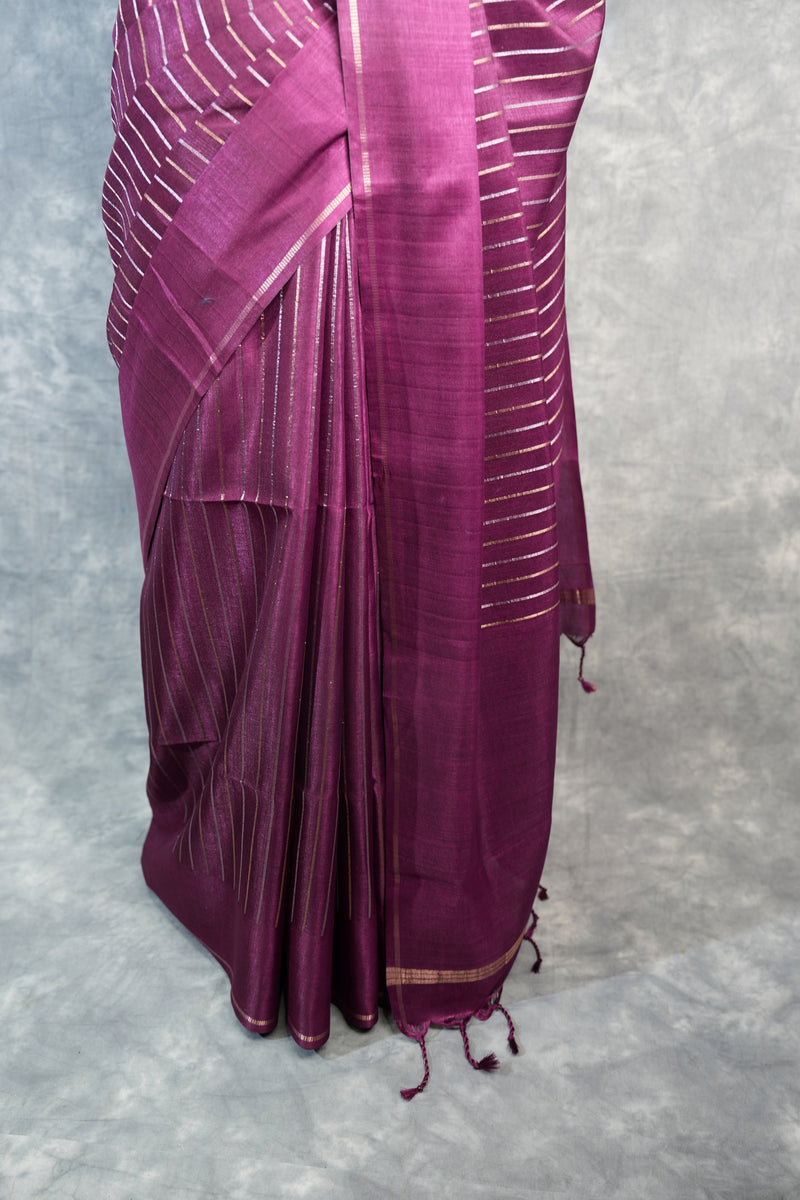 Folded purple fabric with gold accents on a textured gray background