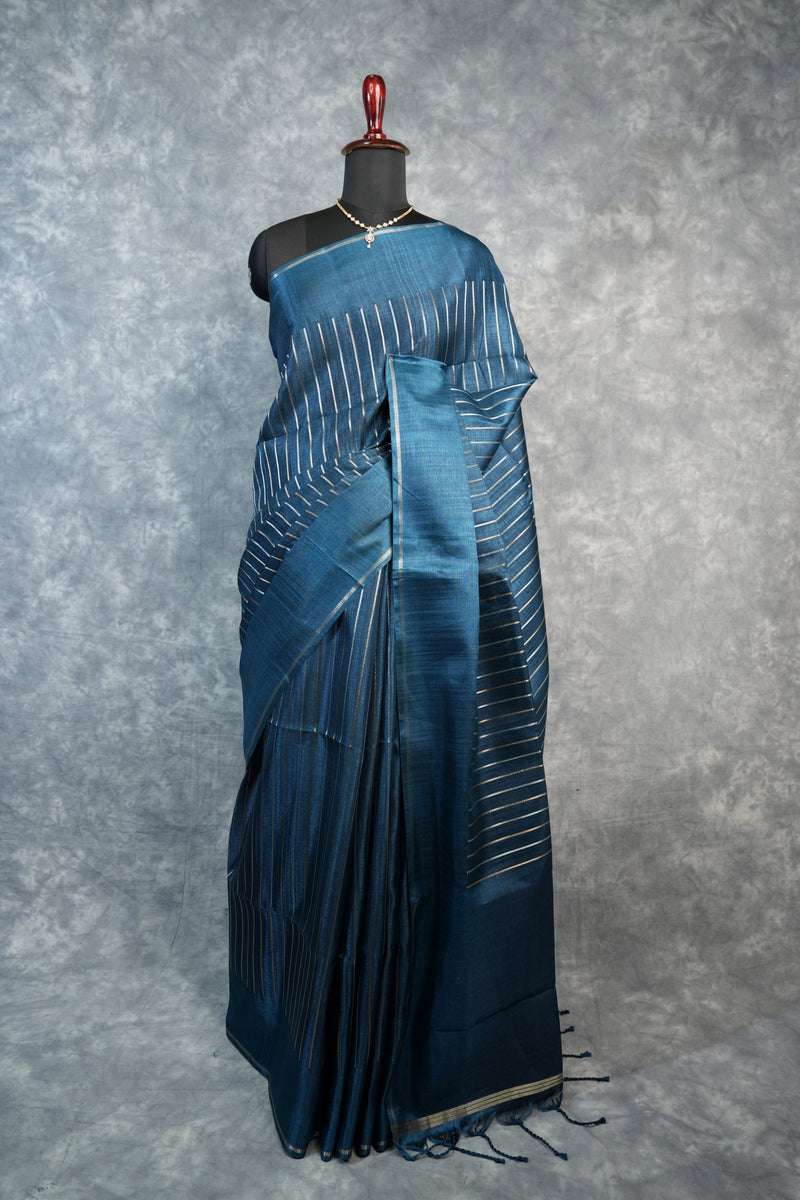 Blue saree with white patterns on a mannequin against a gray background