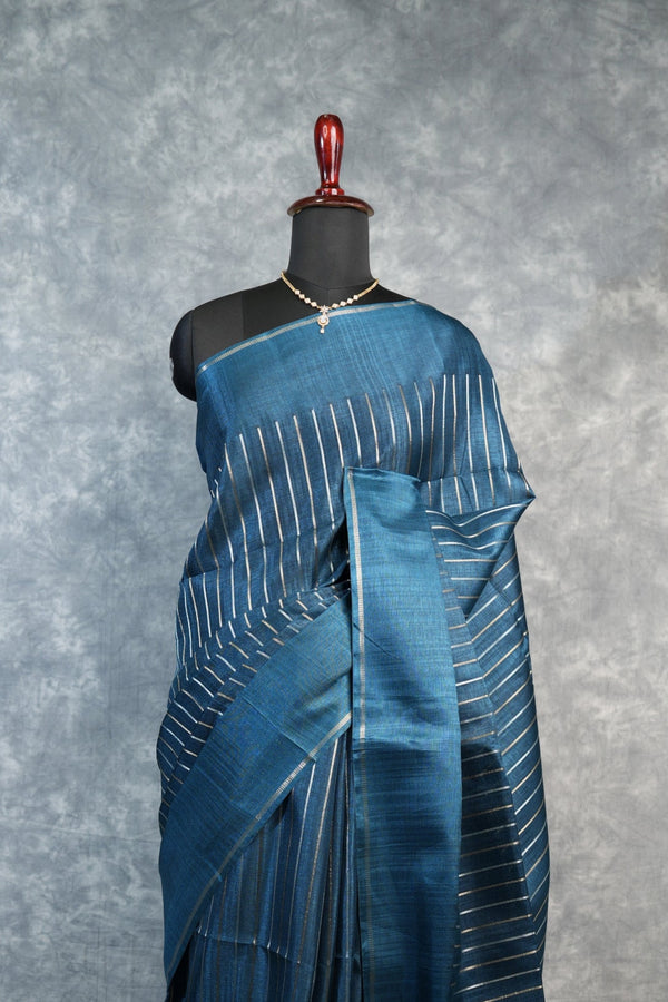 Blue saree with white patterns on a mannequin against a gray background