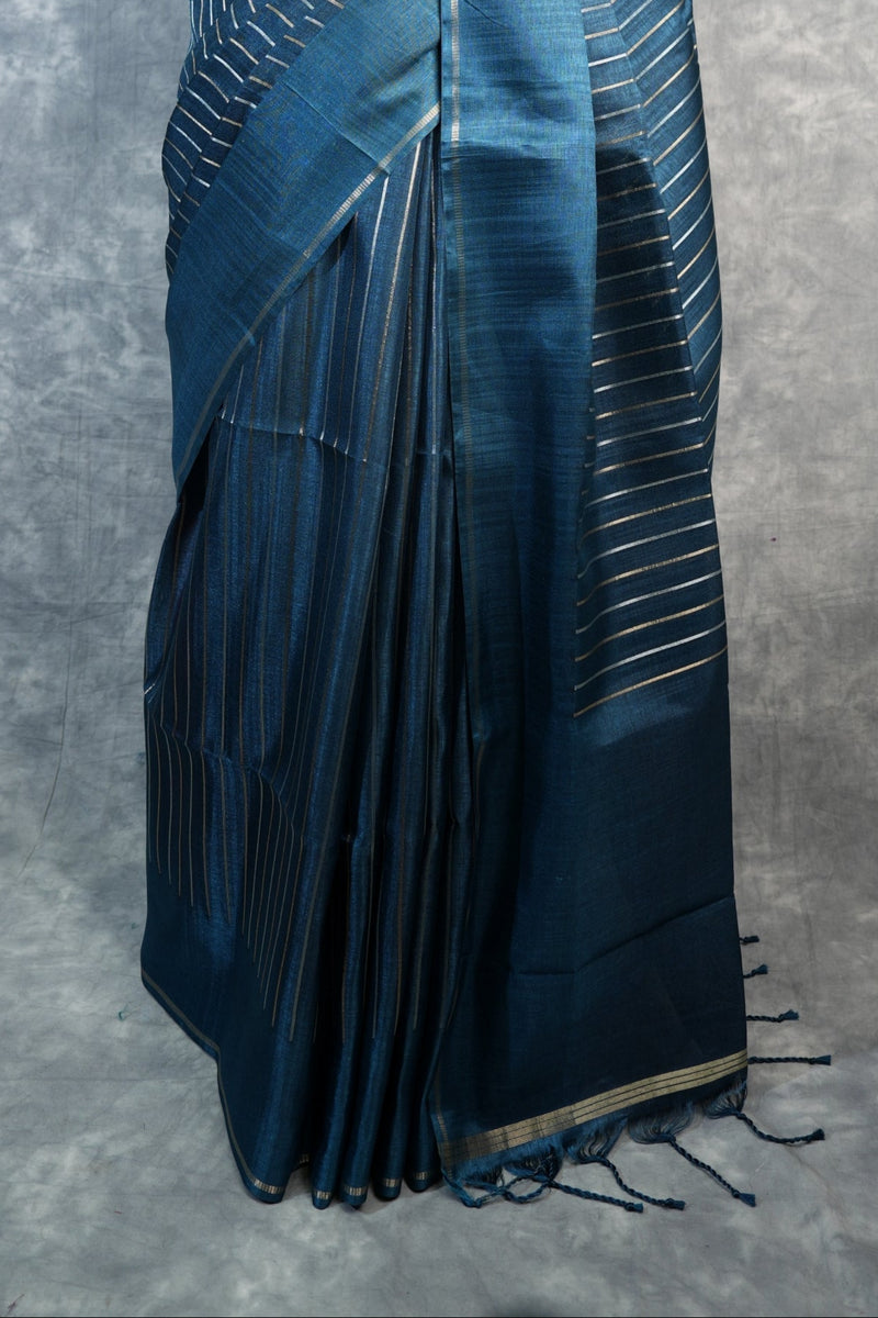Blue saree with white patterns on a mannequin against a gray background
