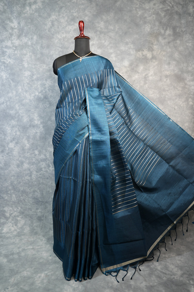Blue saree with white patterns on a mannequin against a gray background