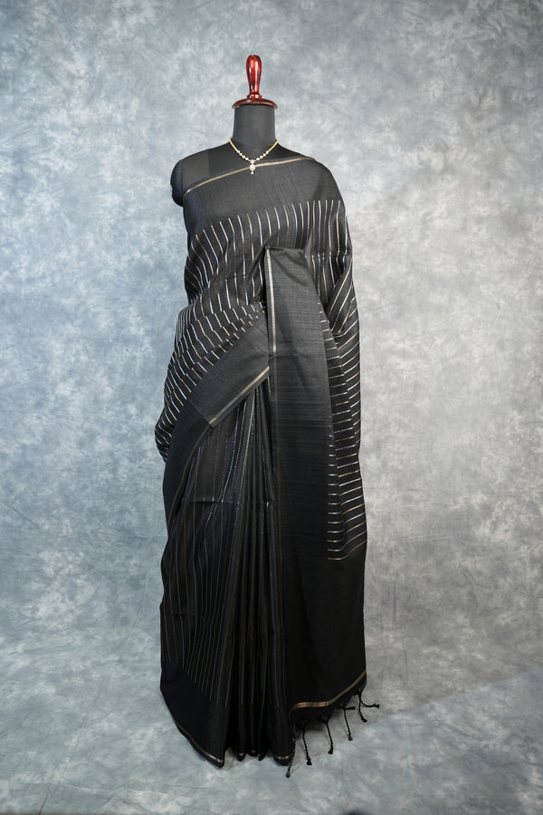 Black saree with white patterns on a mannequin against a gray background
