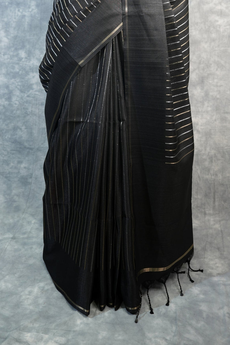 Black saree with white patterns on a mannequin against a gray background