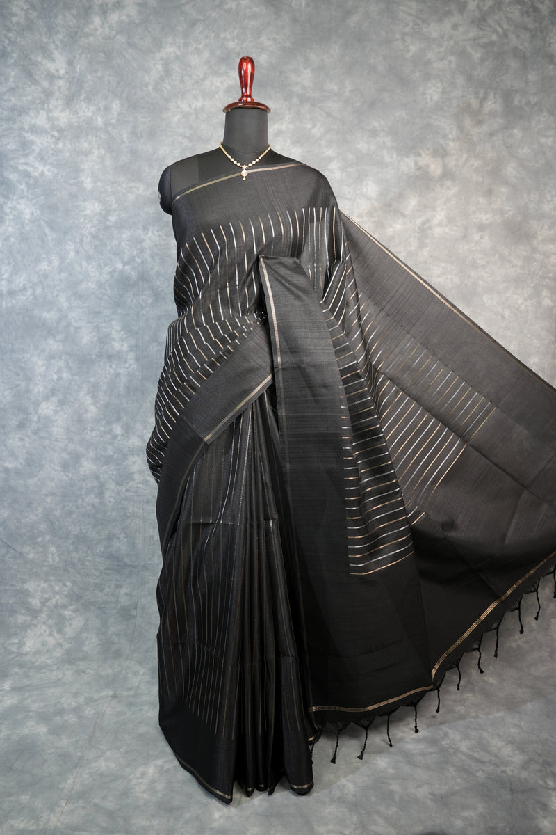 Black saree with white patterns on a mannequin against a gray background