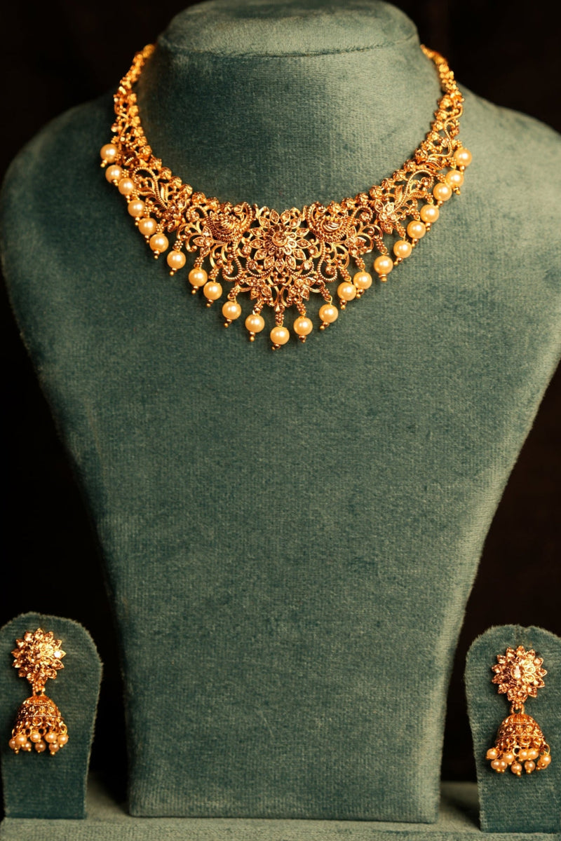 Green velvet dress with gold embroidery on a black background