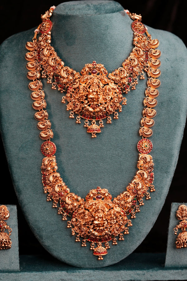 Decorative headband with intricate gold design on a teal stand against a dark background