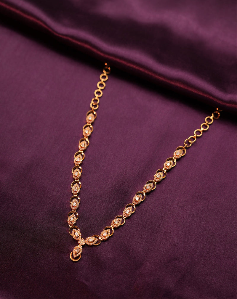 Gold necklace on a purple fabric background