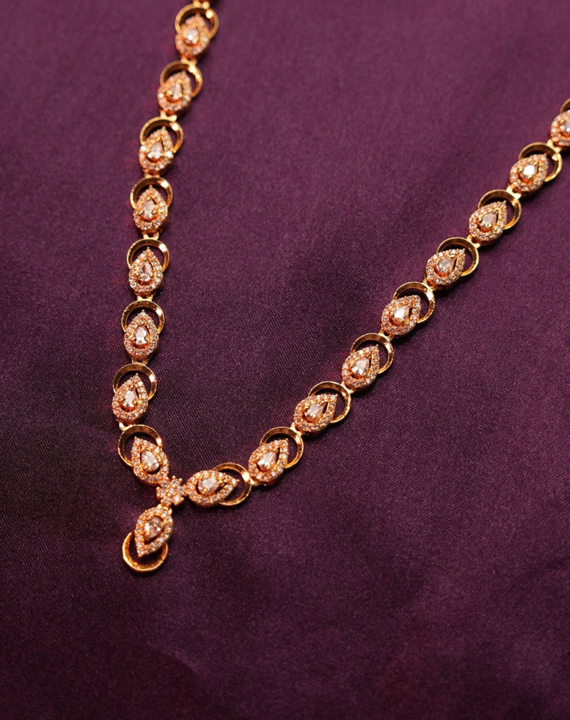 Gold necklace on a purple fabric background