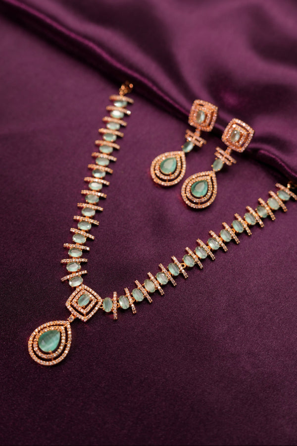Necklace with green gemstones on a purple fabric background