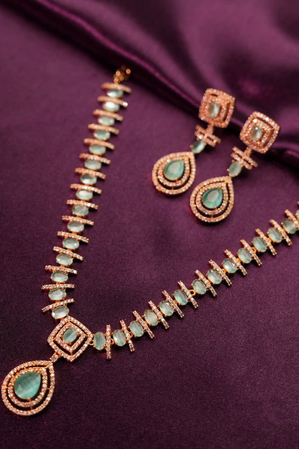 Necklace with green gemstones on a purple fabric background