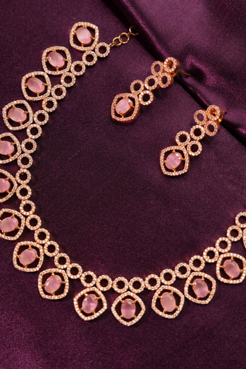 Gold bracelet with pink gemstones on a purple fabric background