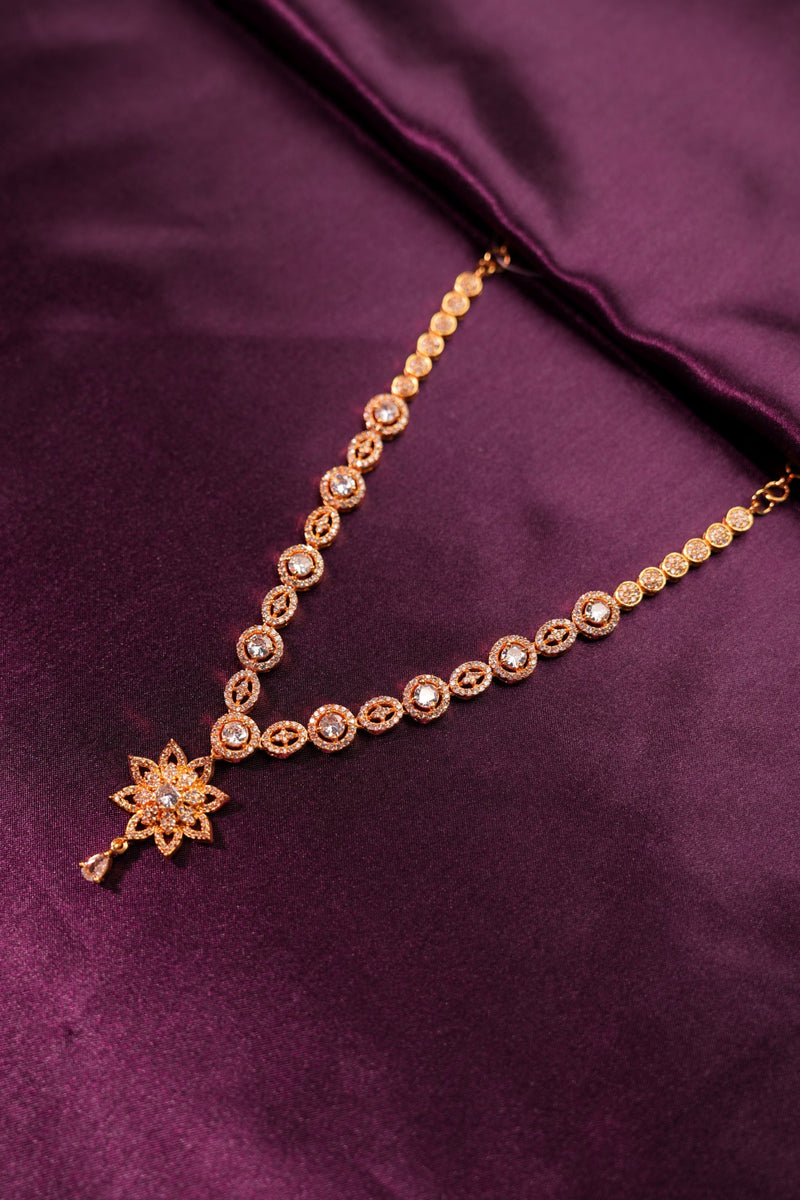 Gold bracelet with star-shaped clasp on a purple fabric background