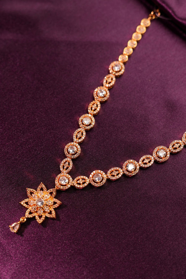 Gold bracelet with star-shaped clasp on a purple fabric background