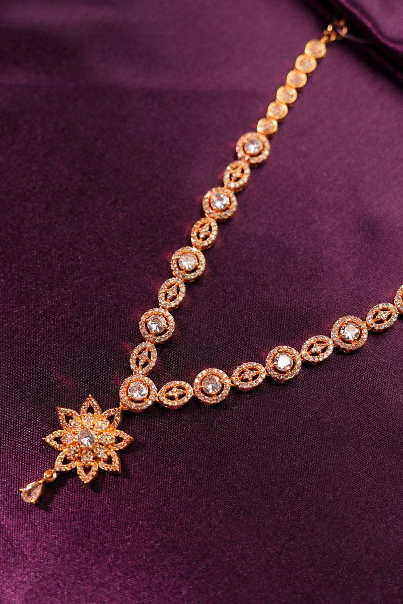 Gold bracelet with star-shaped clasp on a purple fabric background