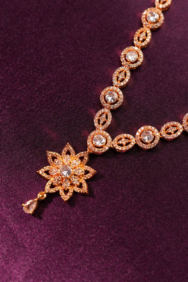 Gold bracelet with star-shaped clasp on a purple fabric background