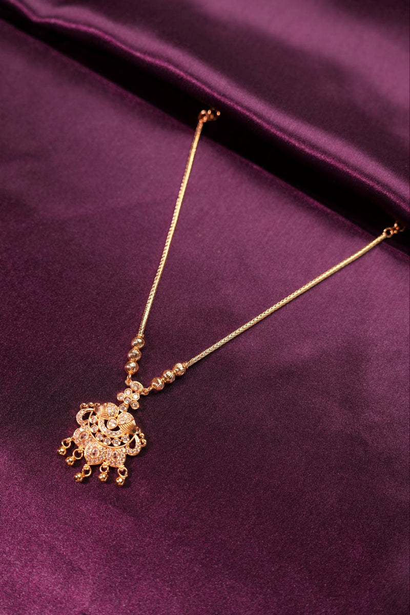 Gold hairpin with decorative elements on a purple fabric background