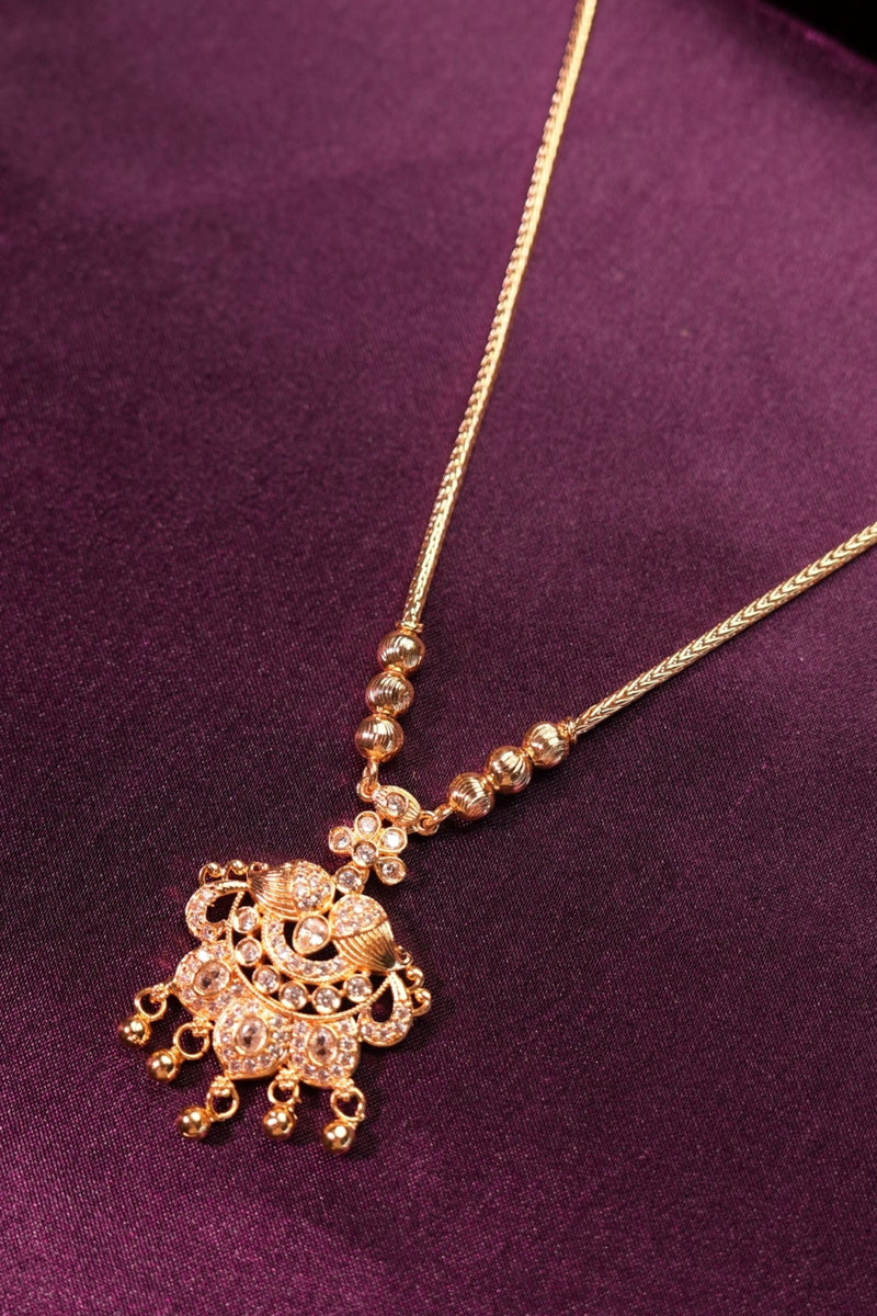 Gold hairpin with decorative elements on a purple fabric background