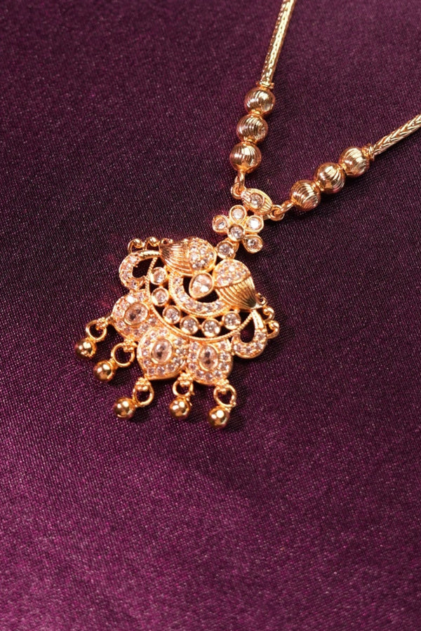 Gold hairpin with decorative elements on a purple fabric background
