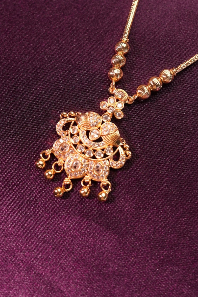 Gold hairpin with decorative elements on a purple fabric background