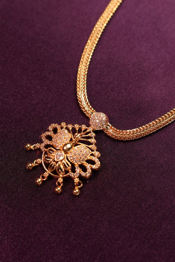 Gold necklace with decorative clasp on a purple fabric background