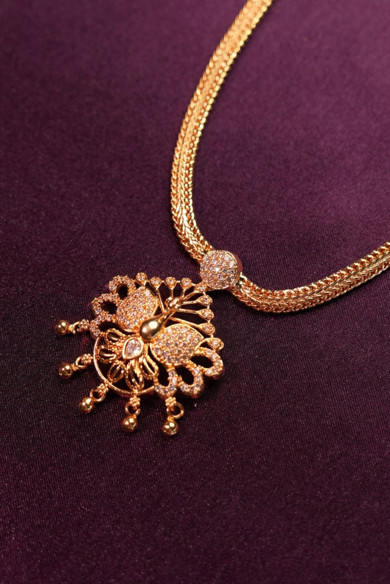 Gold necklace with decorative clasp on a purple fabric background