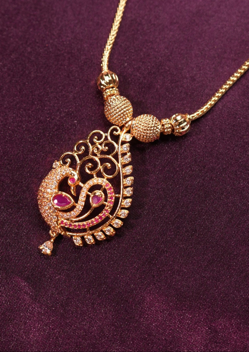 Gold necklace with a pendant on a purple fabric background