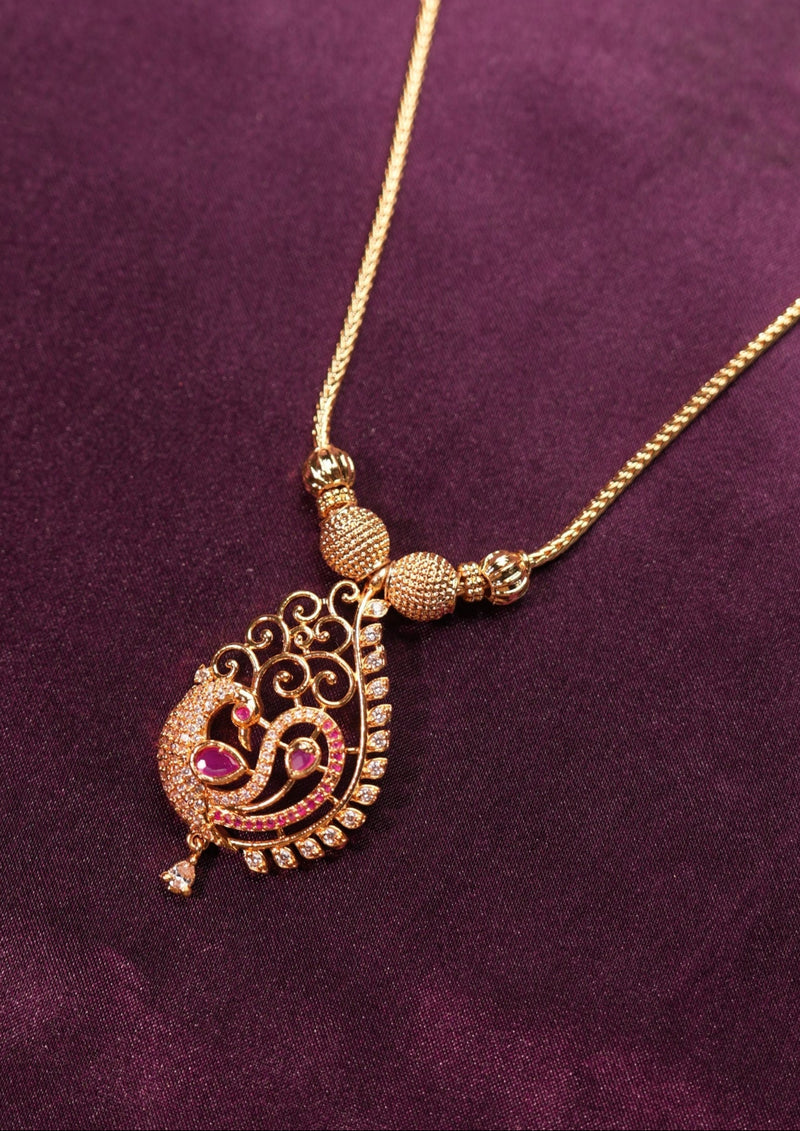 Gold necklace with a pendant on a purple fabric background