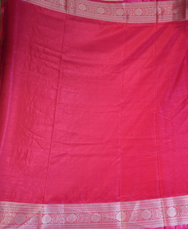 A bright pink silk saree or fabric panel with traditional woven borders, displayed flat.