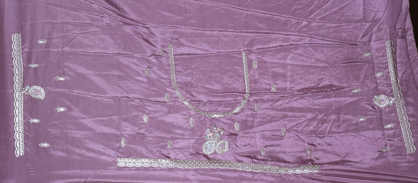 A Mauve satin fabric, likely a dupatta or sari, featuring silver mirror work embroidery and metallic embellishments arranged symmetrically.