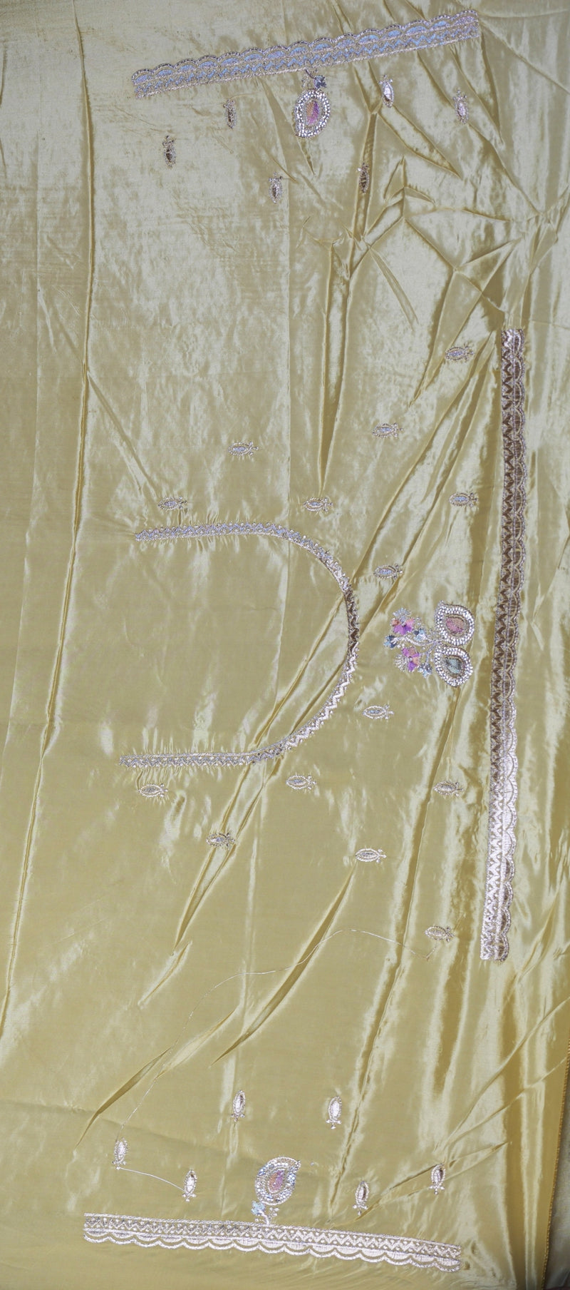 A light gold satin fabric panel with pink and silver floral embroidery and decorative borders, laid flat.