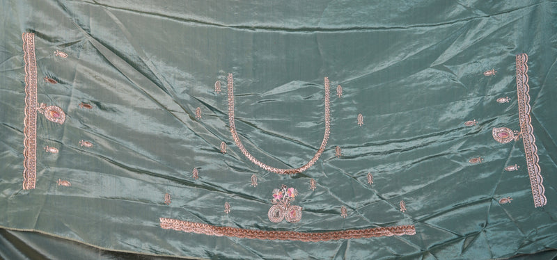 A sage green satin-like fabric with pink and gold embroidery, laid flat. The fabric features a central U-shaped neckline design, a horizontal band near the bottom, and vertical decorative borders on both sides.