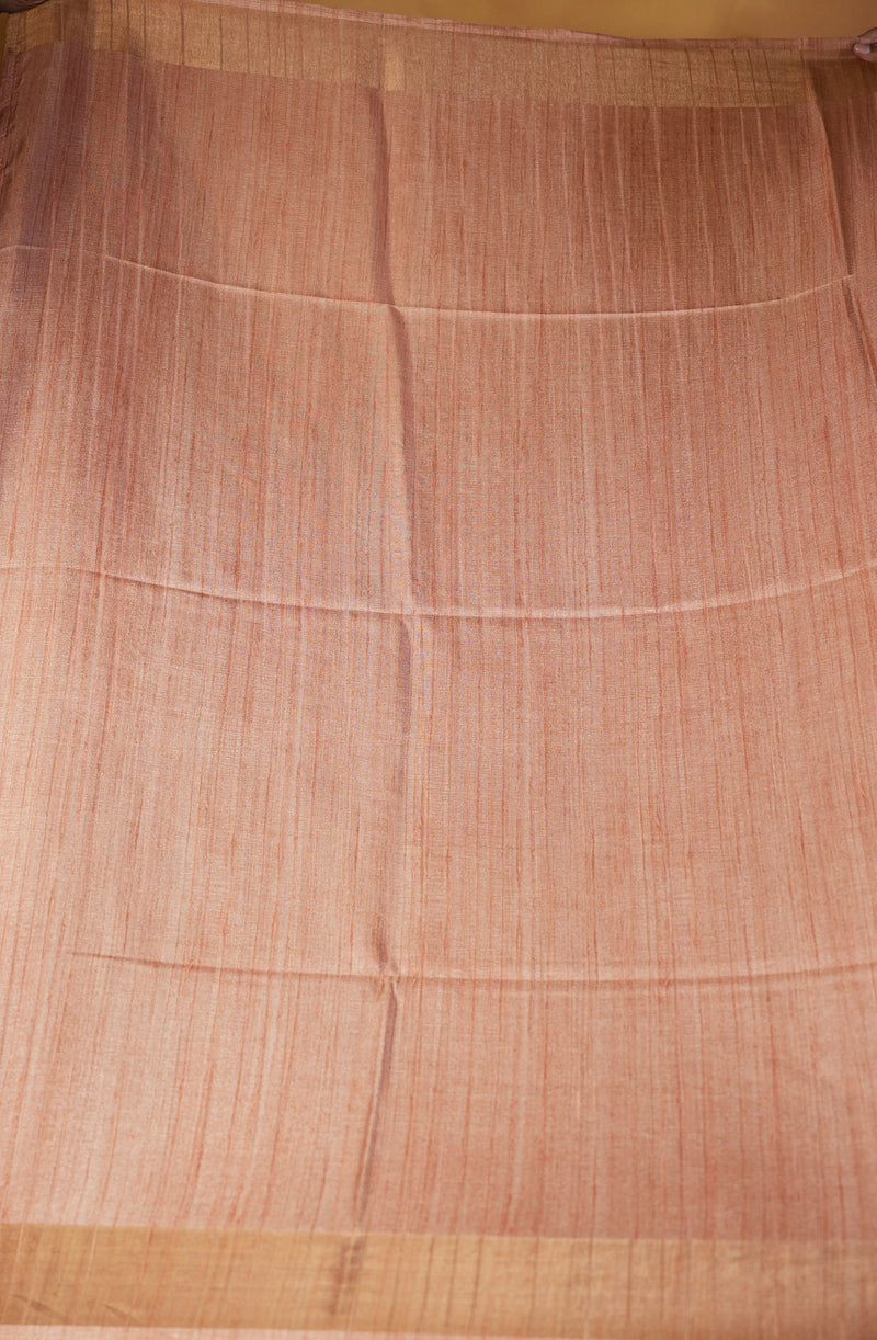 A peach-colored woven fabric, likely a sari or scarf, featuring a fine vertical striped pattern and a solid golden-beige border at the bottom.