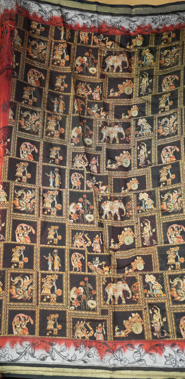 A black fabric textile featuring a grid of small illustrated panels with figures, elephants, and decorative motifs in gold, red, beige, and white, plus a patterned border at the top and bottom.