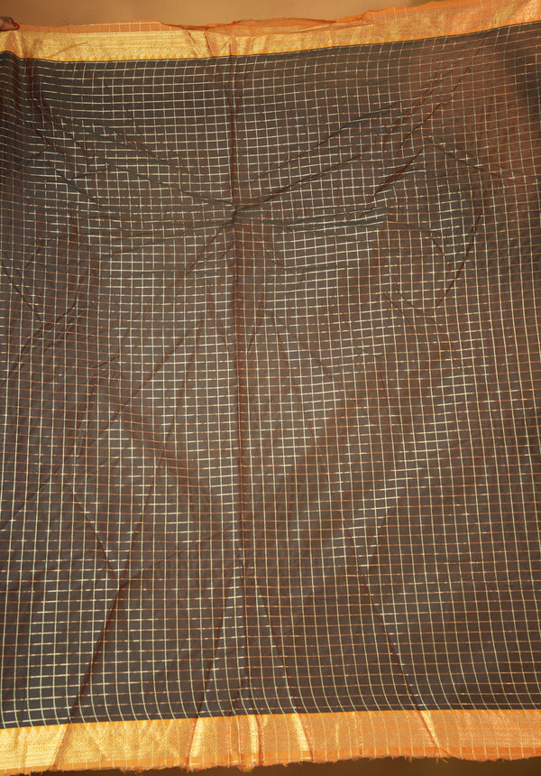 A dark brown checkered saree fabric with a shiny gold border, laid flat and showing its woven grid pattern.
